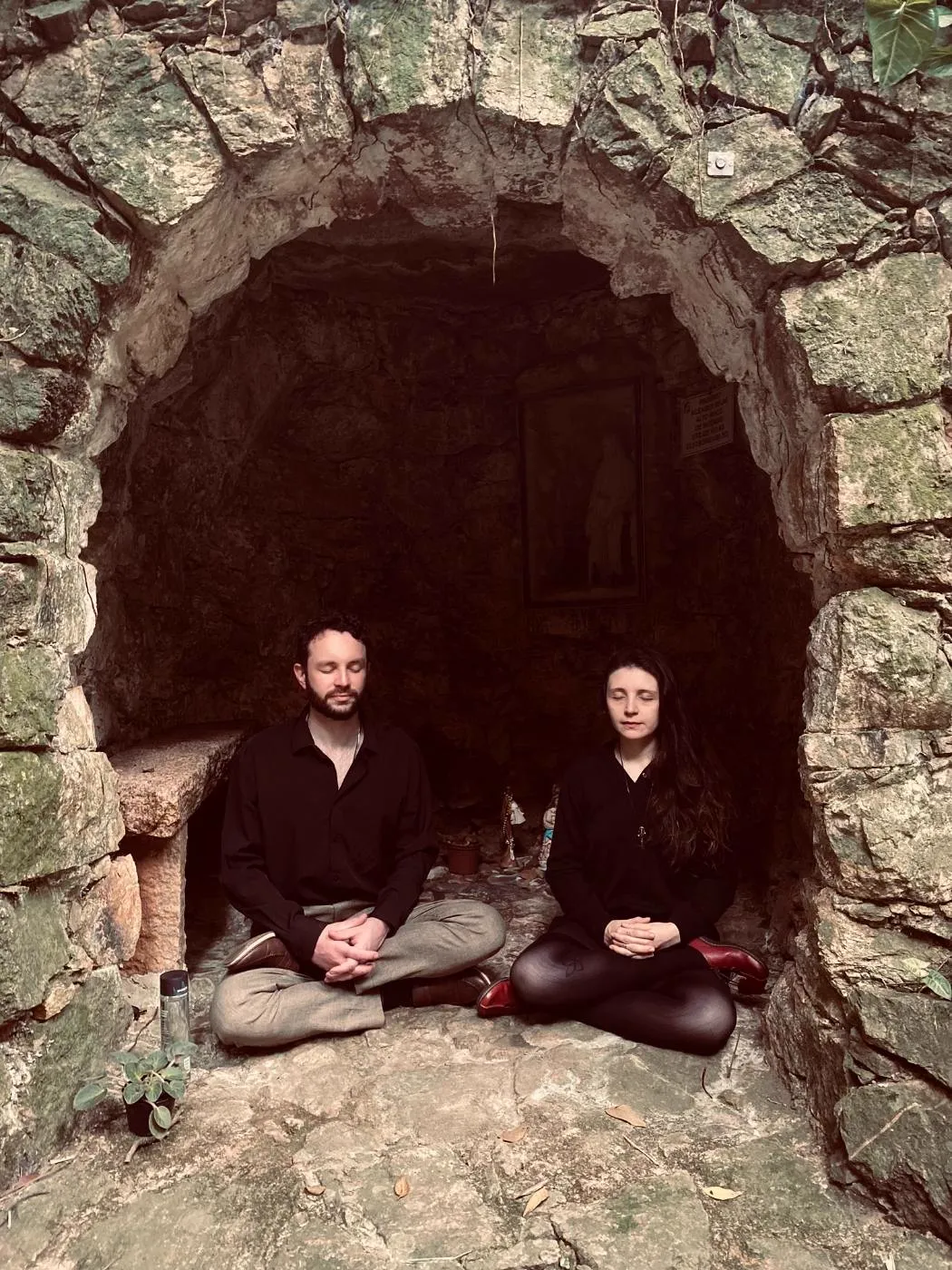 Paola e Yuri em meditação numa gruta de pedra