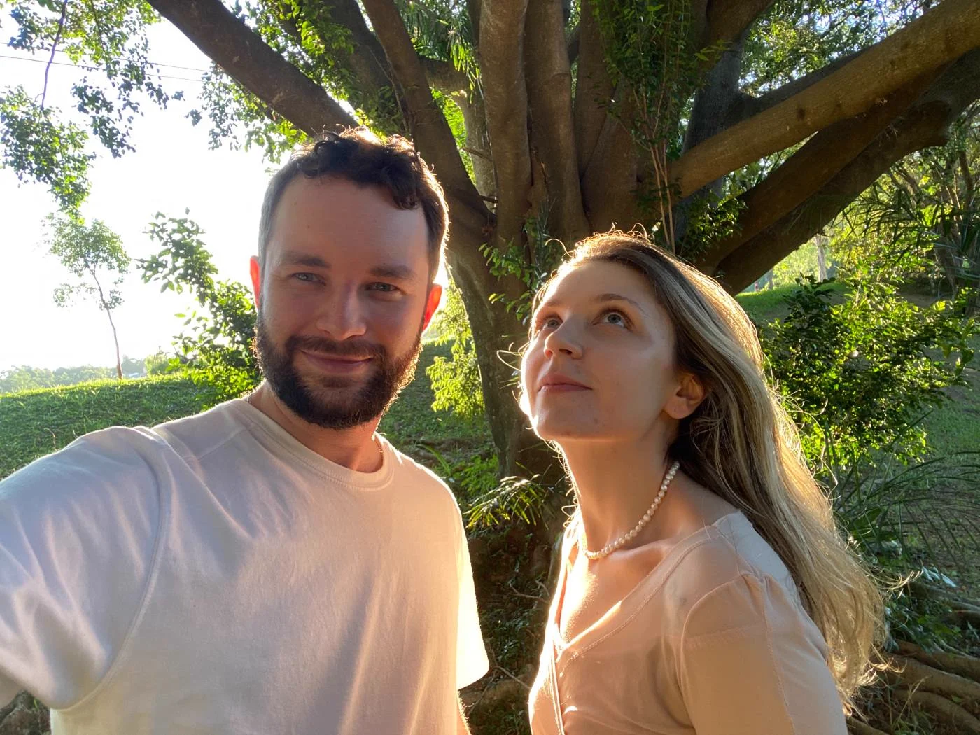 Paola e Yuri sob uma árvore ao sol